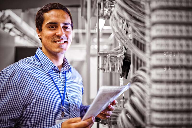 Portrait of technician analyzing server in server room